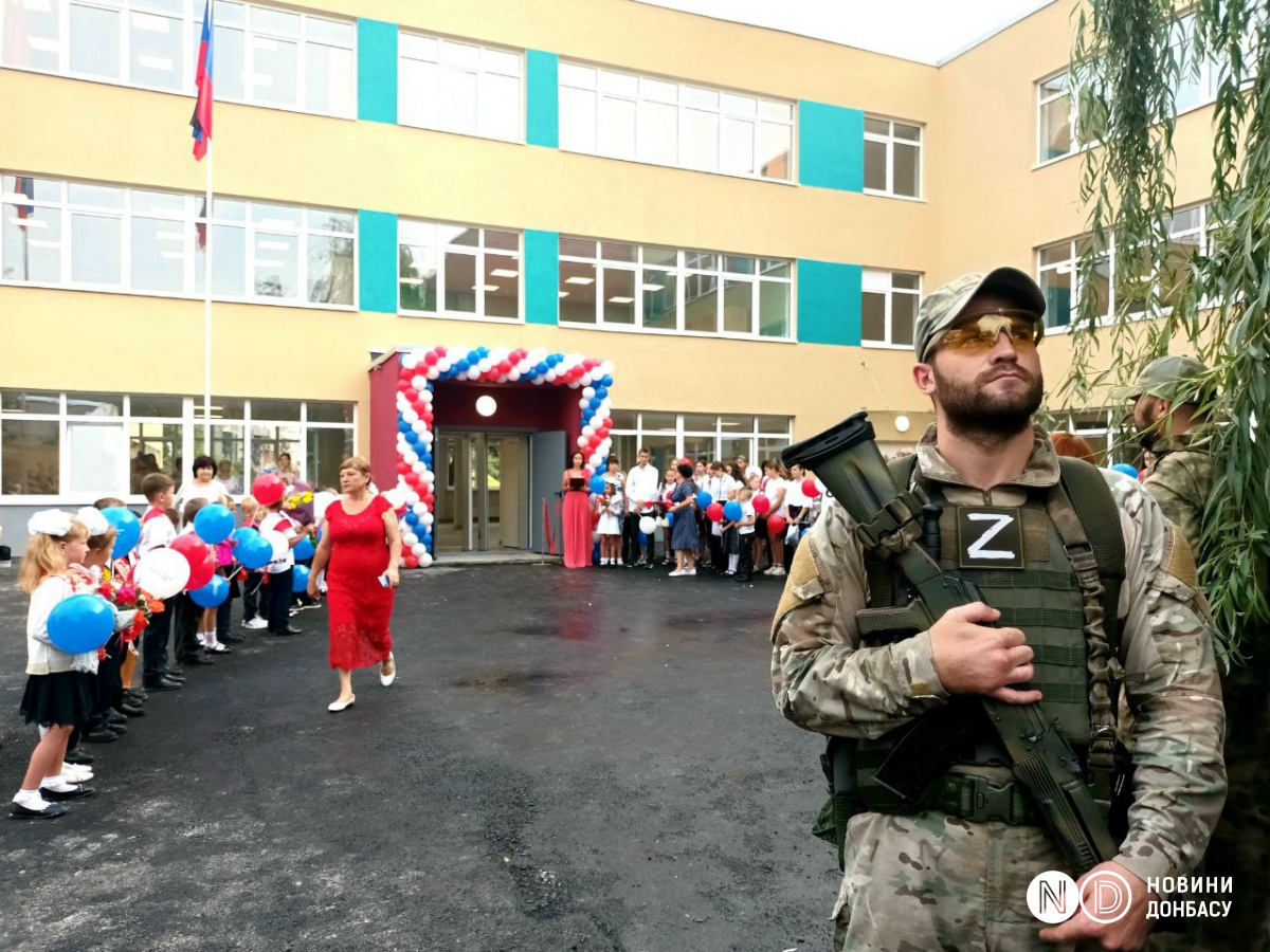 Оккупант у входа в школу в оккупированном Мариуполе, 1 сентября 2022 года. Фото: Виктория Рощина / Новости Донбасса