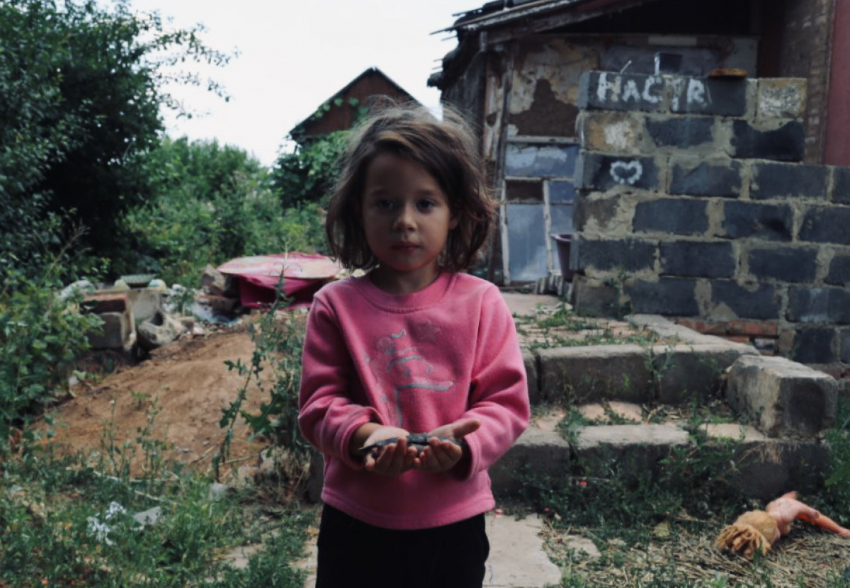 Дівчинка Ліза з Бахмута показує зібрані уламки снарядів, липень 2022 року. Фото: Вікторія Рощина / Новини Донбасу