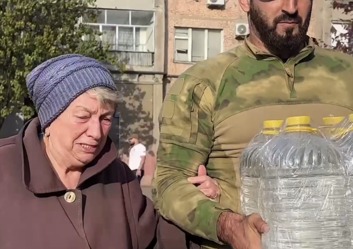 Скрин відео, на якому мешканка Донецька плаче побачивши російських «військових»-волонтерів, які привезли їй питну воду.
