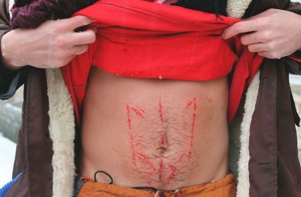 Возле офиса донецкого губернатора голый мужчина вырезал на своем теле герб Украины